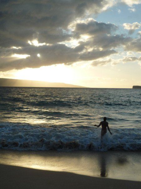 A bodysurfer wading into sunset waves at Little Beach